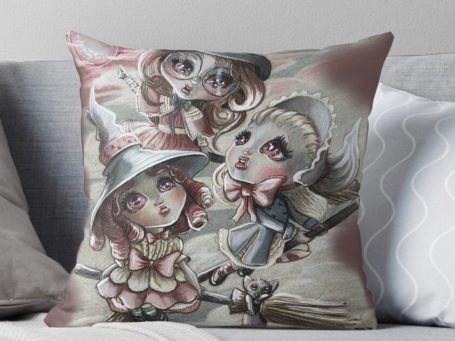 Three cute big eyed witches flying on brooms with a red moon artwork printed on Redbubble pillow