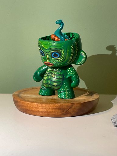 Side view of Creature of the black lagoon painted munny figure with 3D printed and painted Nessie in it’s head.